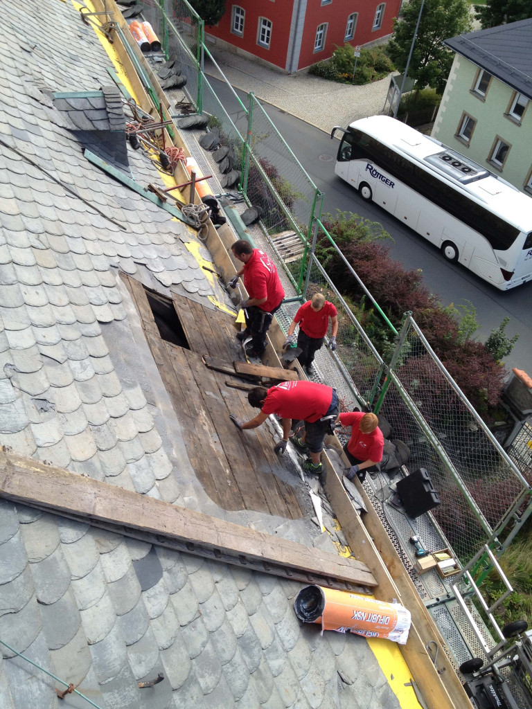 Dachdecker bei der Arbeit am Kirchenschiff